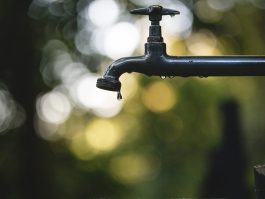 tilt shift lens photography of black steel faucet