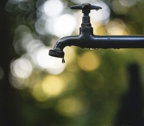 tilt shift lens photography of black steel faucet